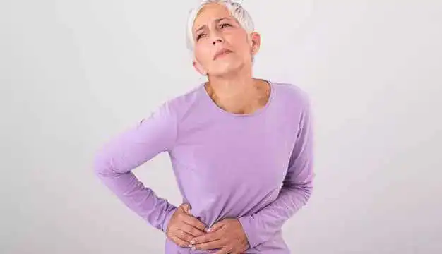 Woman holding her side because of abdominal pain